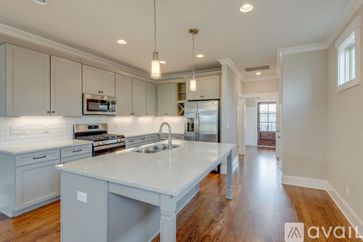A kitchen with a white countertop and wooden floors.