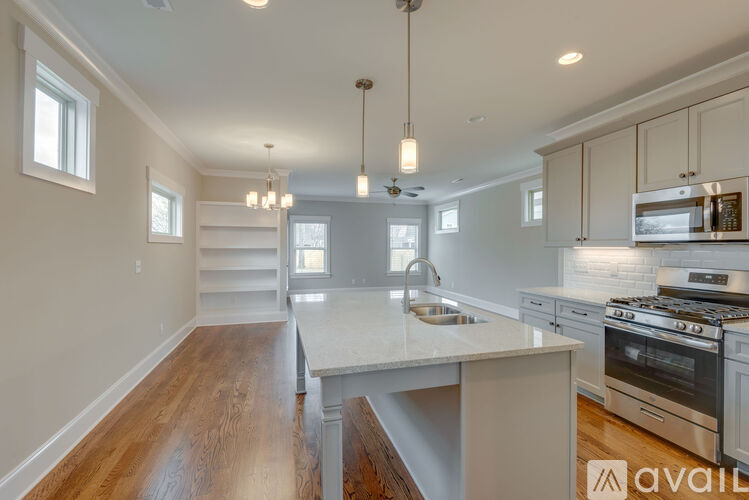 A kitchen with a white countertop and wooden floors.