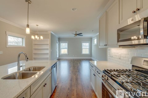 A kitchen with a stove top oven and a sink.