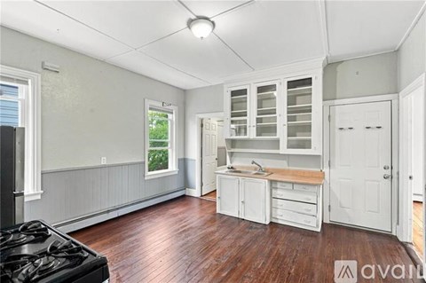 A kitchen with white cabinets and a black stove top oven.