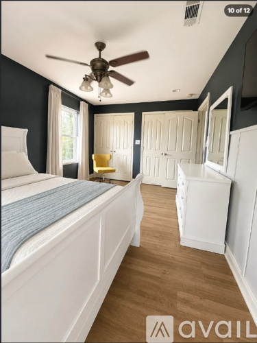 A bedroom with a bed, dresser, and mirror.