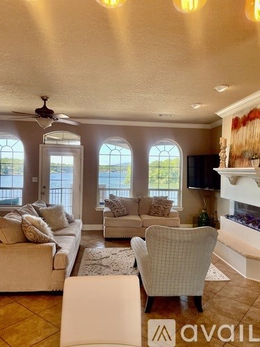 A living room with a couch, chair, and television.