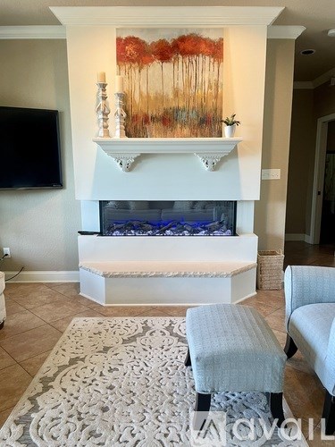 A living room with a fireplace and a painting above it.