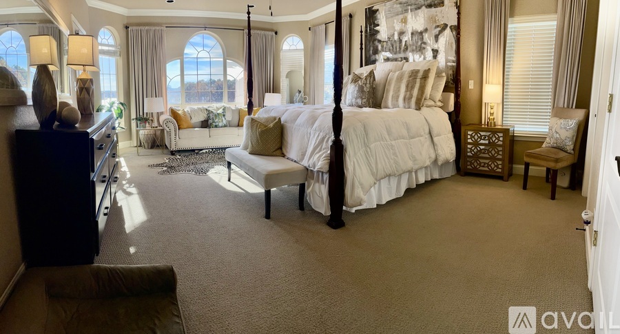 A bedroom with a large bed and a living area with a couch.
