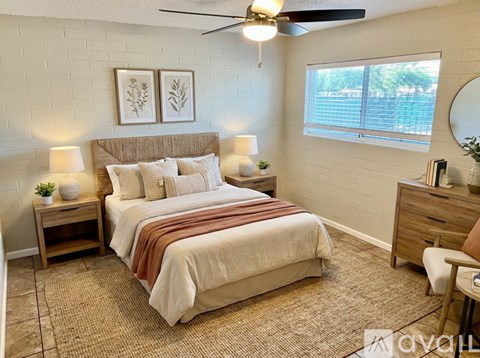A bedroom with a bed, nightstands, and a ceiling fan.