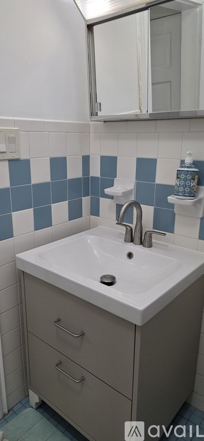 A bathroom with a sink and a mirror.