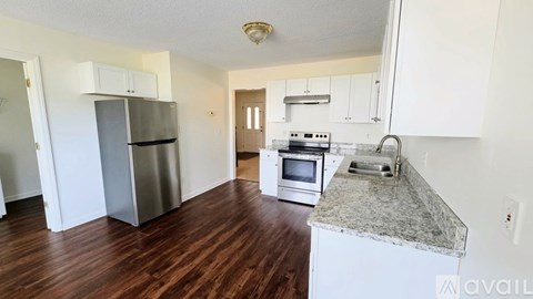 A kitchen with a refrigerator, microwave, oven, and stove top.