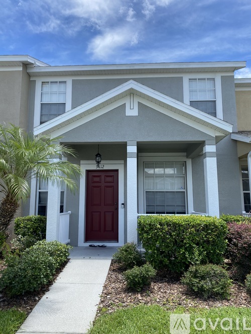 A house with a red door and a white fence.