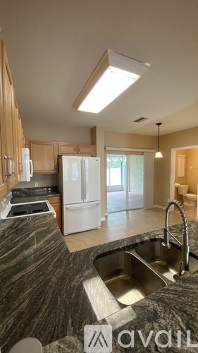 A kitchen with a marble countertop and a sink.