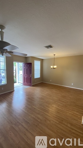 A room with wooden floors and a ceiling fan.