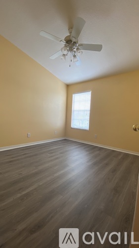 A room with a ceiling fan and wooden flooring.
