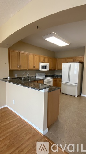 A kitchen with wooden cabinets and a white refrigerator.