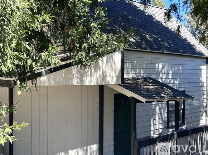 A white house with a green door and a window.