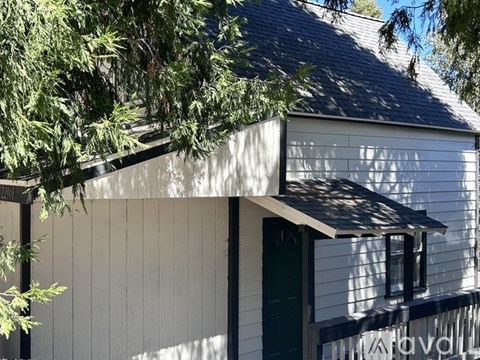 A white house with a green door and a window.