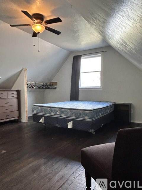 A bedroom with a bed, dresser, and window.