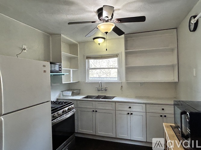 A kitchen with white cabinets and a white refrigerator.