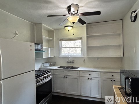 A kitchen with white cabinets and a white refrigerator.