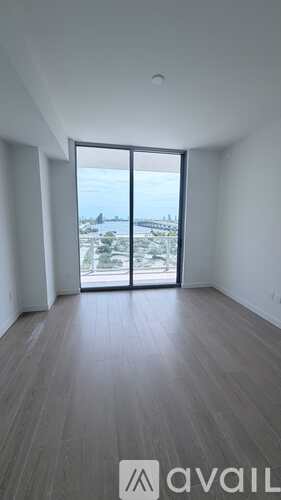 A room with a view of a landscape through a large window.
