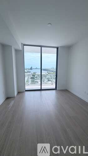 A room with a view of a landscape through a large window.
