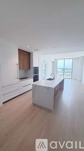 A modern kitchen with wooden floors and white walls.