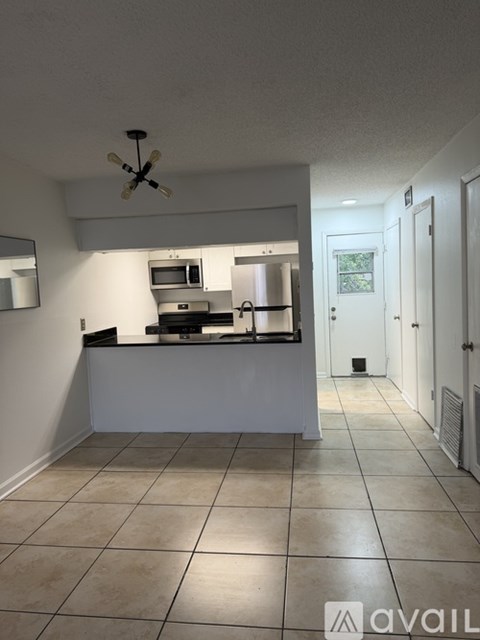 A kitchen with a white counter and a ceiling fan.