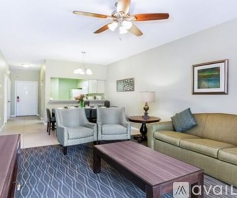 A living room with a couch, chairs, and a coffee table.