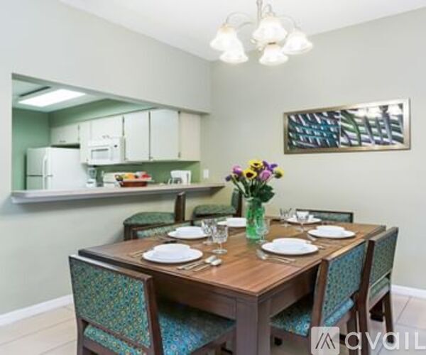 A dining room with a wooden table set for two.
