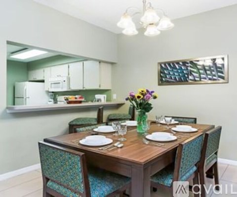 A dining room with a wooden table set for two.