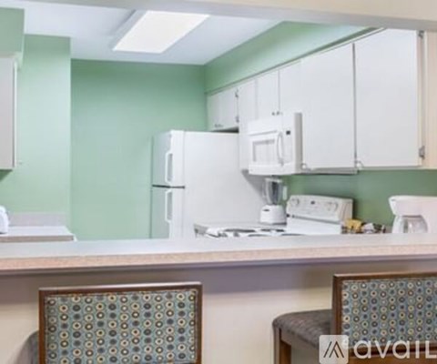 A kitchen with green walls and white appliances.