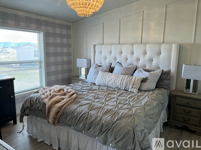 A bedroom with a large bed and a chandelier.