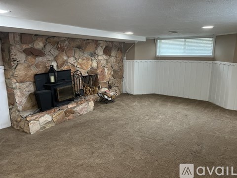 A living room with a stone fireplace and a television.
