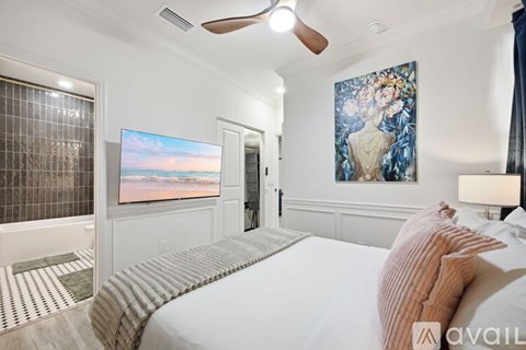 A bedroom with a large bed and a painting on the wall.