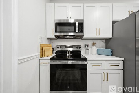 A kitchen with white cabinets and a black stove top.