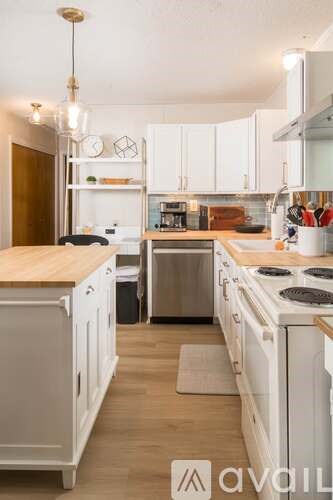 A kitchen with white cabinets and a wooden countertop.