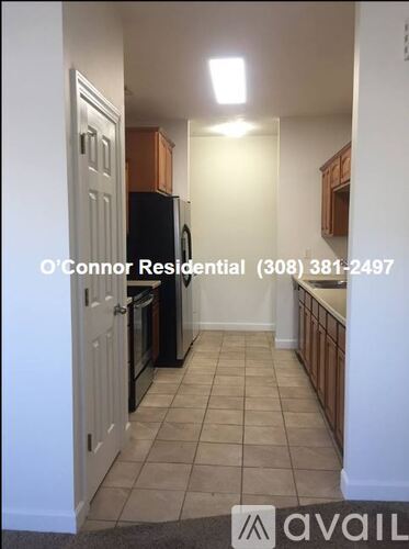 A kitchen with a refrigerator and cabinets is available for rent.