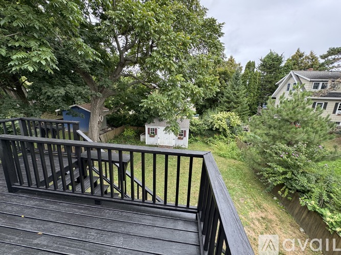 A deck with a railing overlooking a green yard.