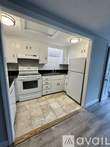 A kitchen with white cabinets and appliances.