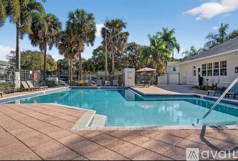 A pool surrounded by palm trees and a fence with a sign that says "available".