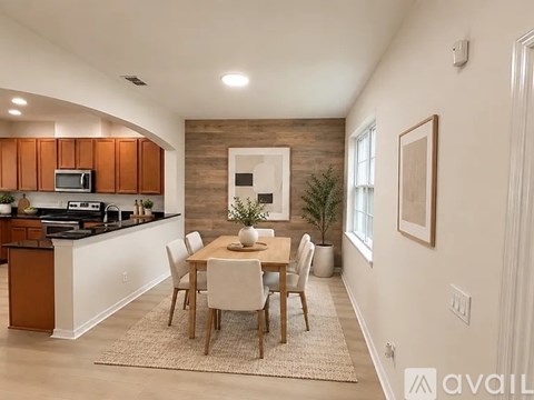 A kitchen with a dining table and chairs.