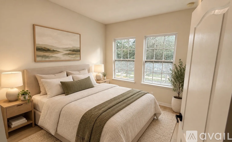 A bedroom with a large bed and a painting on the wall.