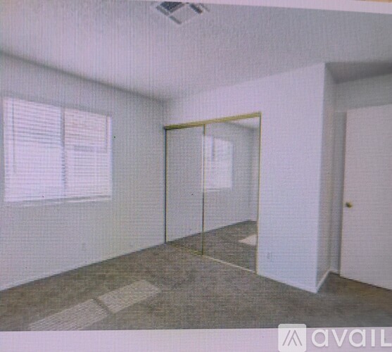 A room with a glass door and a window with blinds.