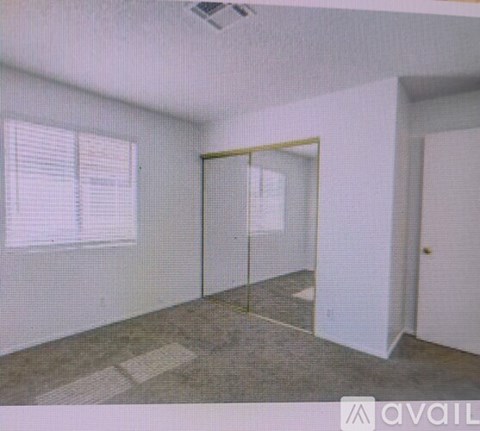 A room with a glass door and a window with blinds.