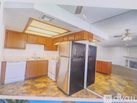 A kitchen with wooden cabinets and a black refrigerator.