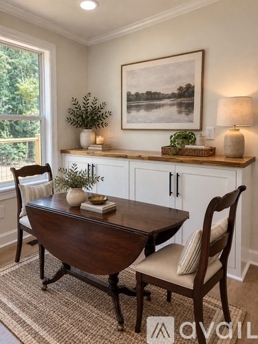 A dining room with a wooden table and chairs.