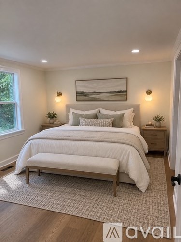 A bedroom with a large bed and a painting on the wall.