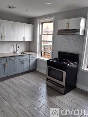 A kitchen with a black stove top oven and a window letting in light.