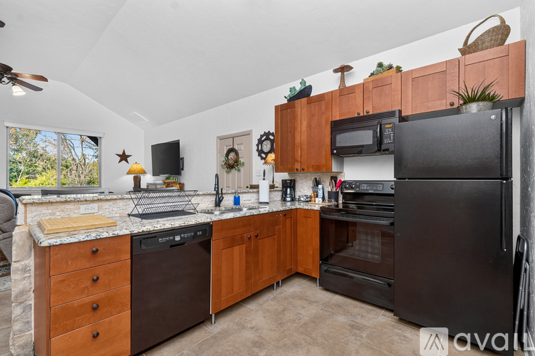A kitchen with a black fridge, microwave and oven.