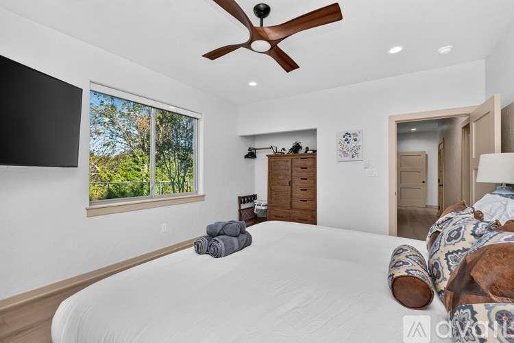 A bedroom with a large bed and a ceiling fan.