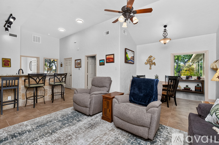 A living room with a grey couch and a ceiling fan.