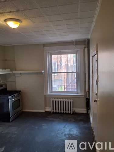 A room with a window and a radiator on the wall.